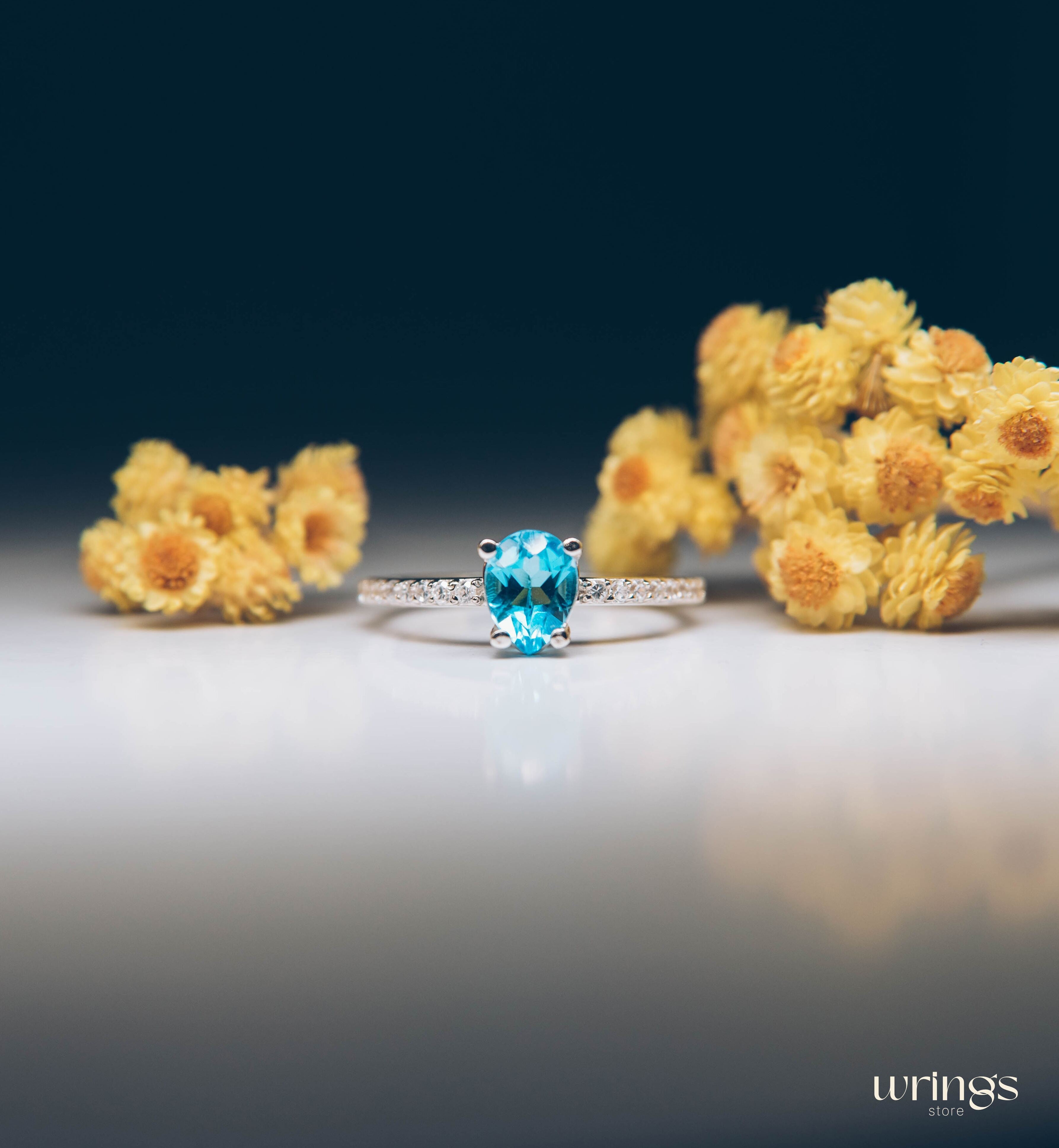 Blue Pear Cut Topaz Engagement Ring & Side CZ Stones