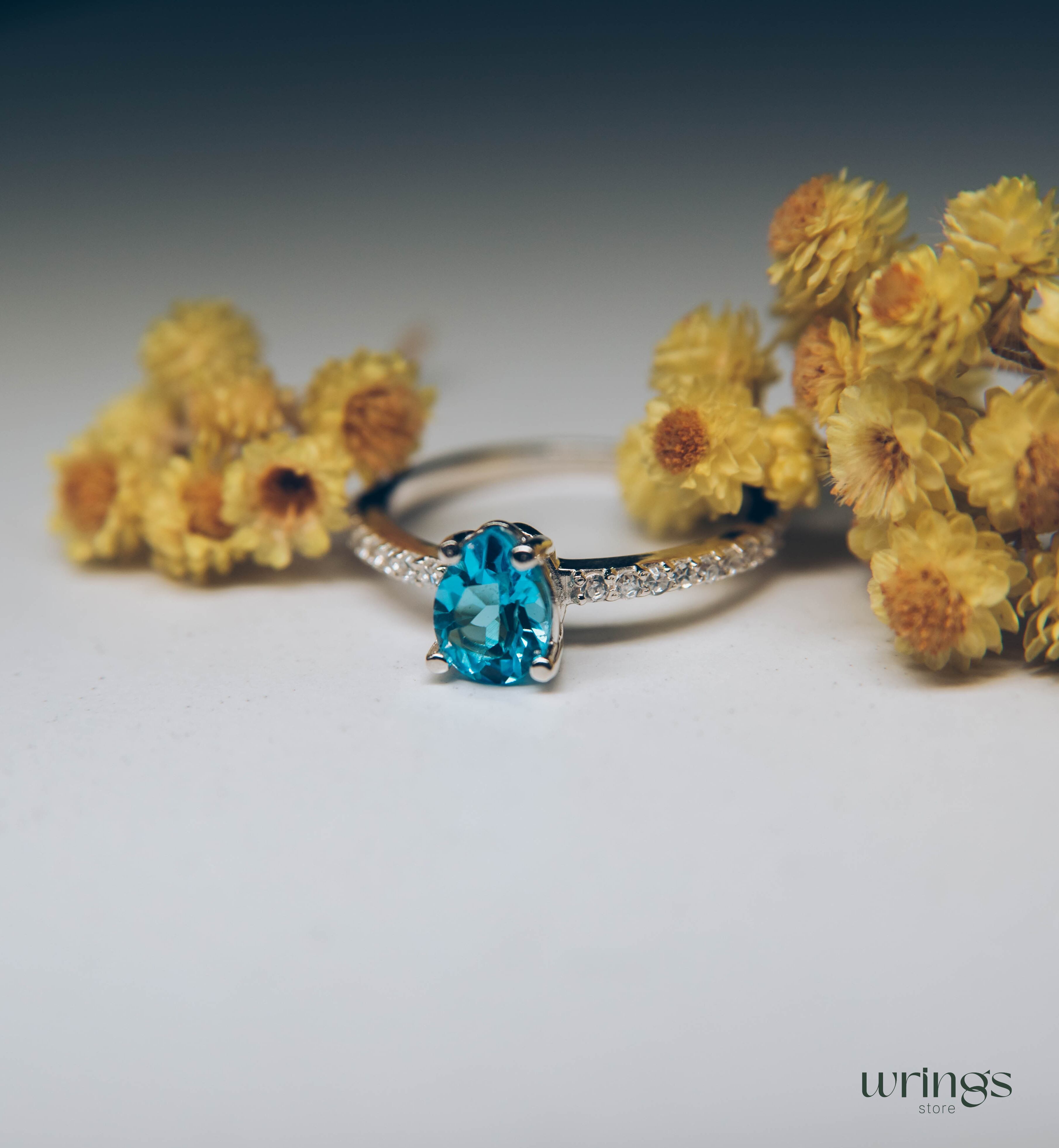 Blue Pear Cut Topaz Engagement Ring & Side CZ Stones