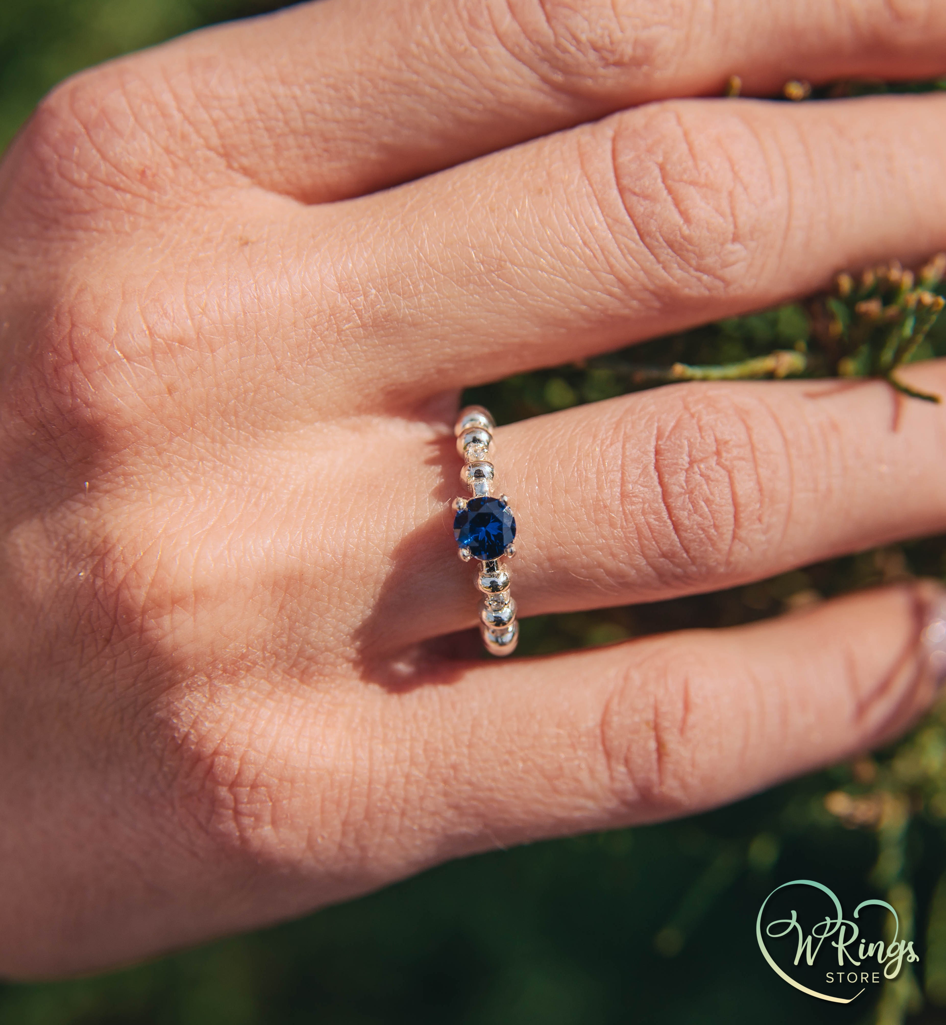 Round Sapphire & Side Stones Engagement Ring with bubbles on band