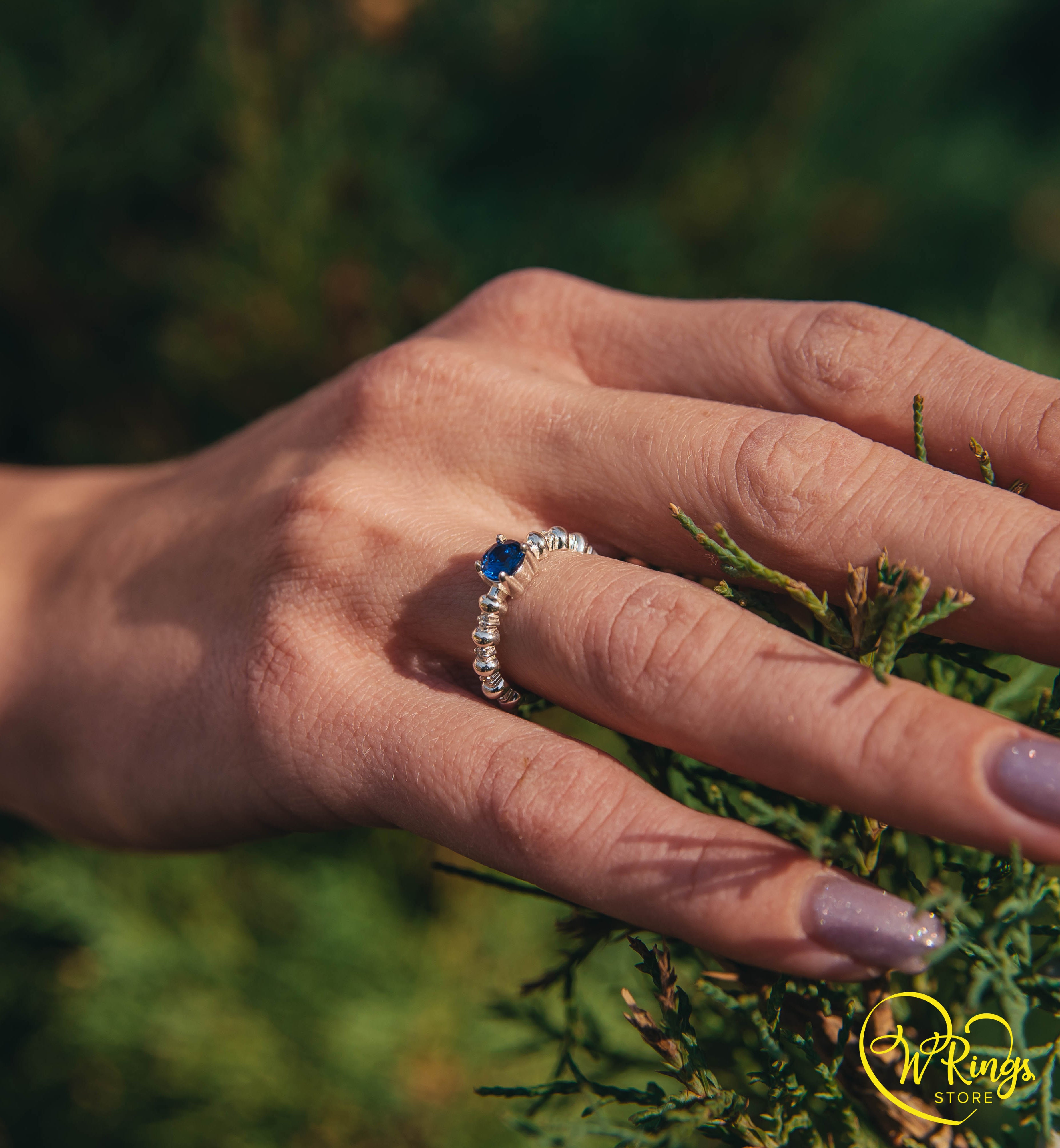 Round Sapphire & Side Stones Engagement Ring with bubbles on band