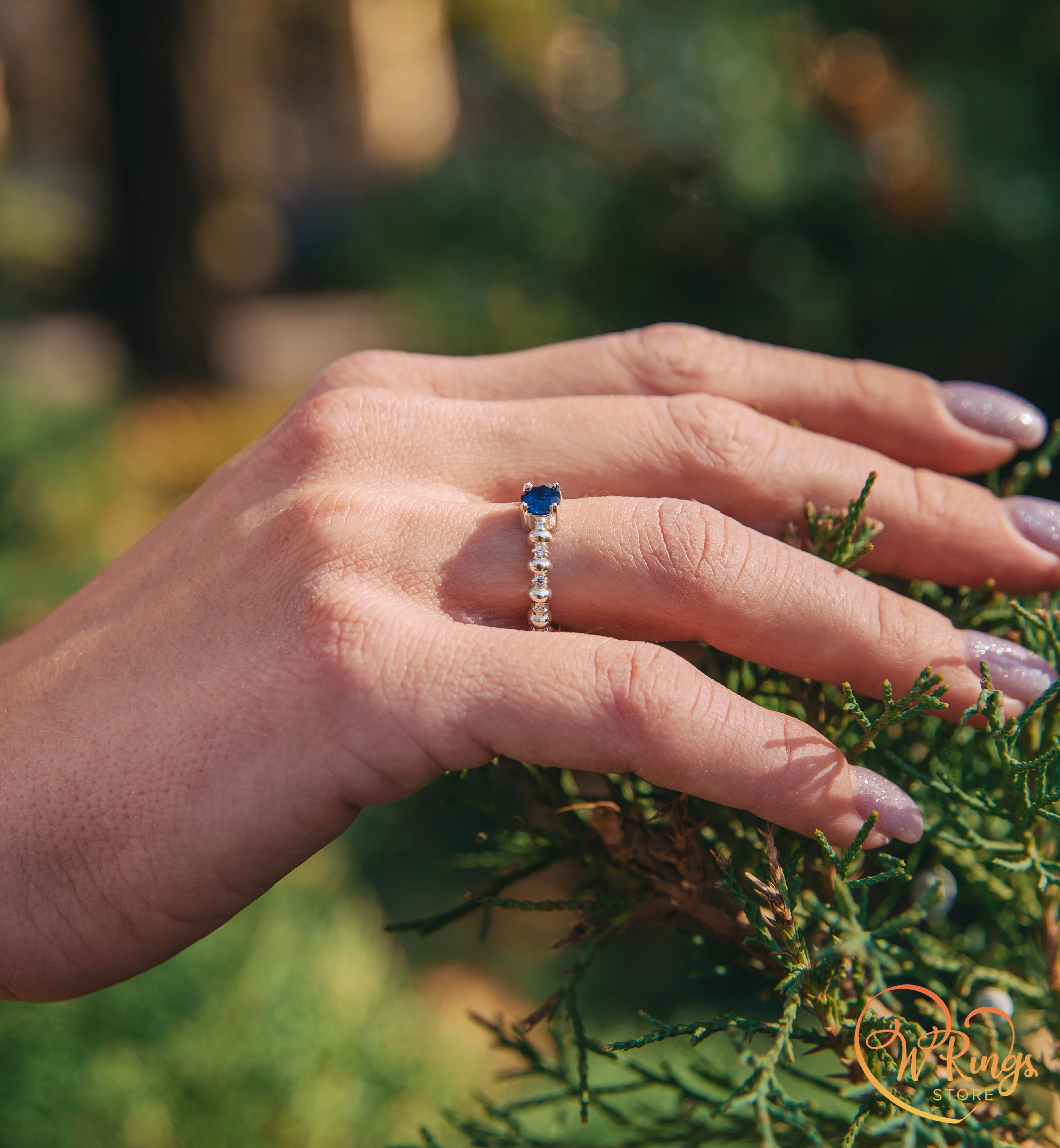 Round Sapphire & Side Stones Engagement Ring with bubbles on band