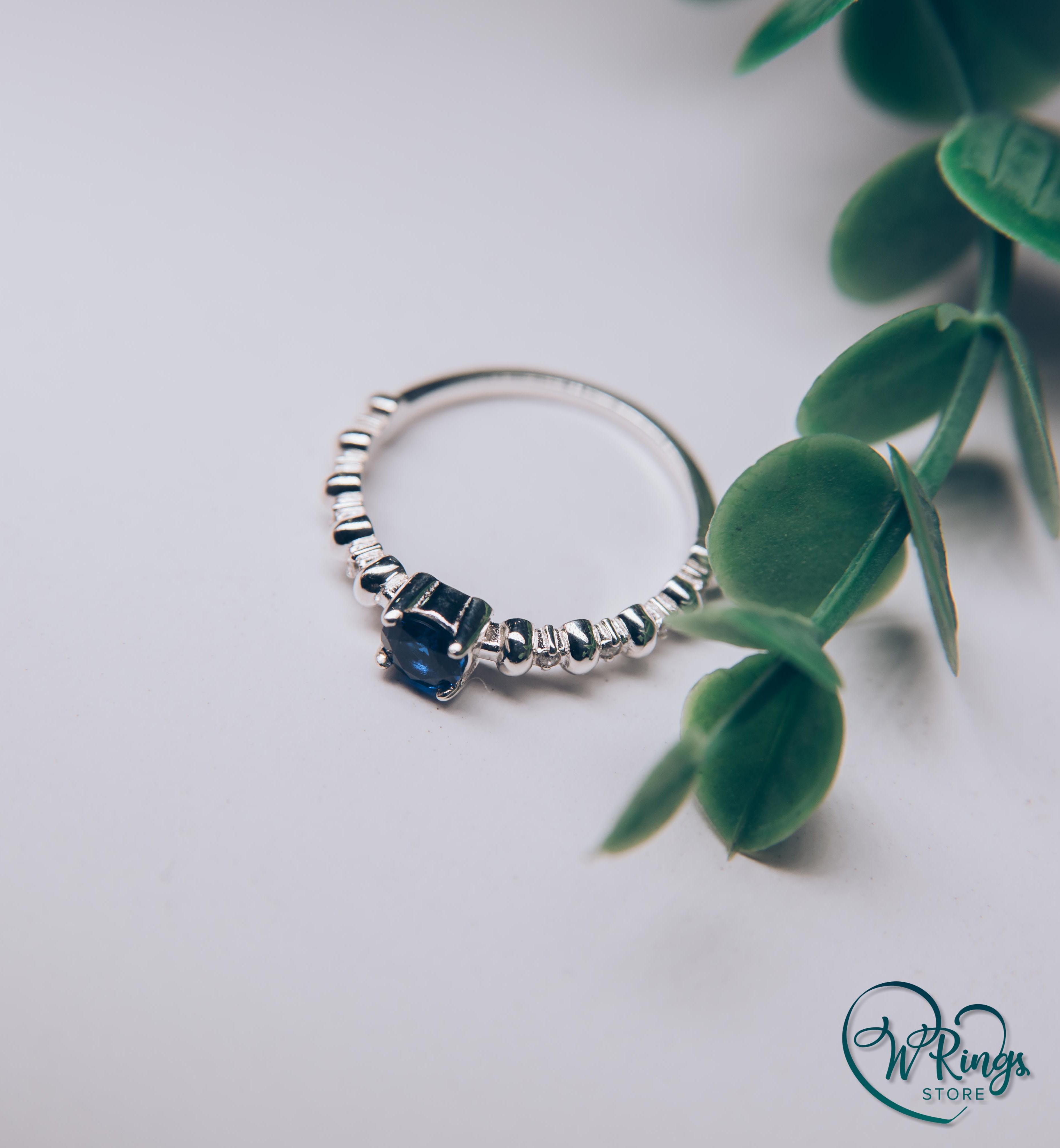 Round Sapphire & Side Stones Engagement Ring with bubbles on band